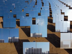 Aerial shot of reflective solar panels in the desert showcasing renewable energy.