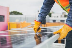 A solar technician performing maintenance on solar panels outdoors.